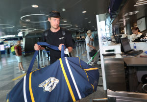 Flera finländska NHL-stjärnor reste till Nordamerika den 26 juni. Pekka Rinne lyfter lyfter sin hockeyväska på transportbandet.