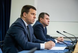 Premiärminister Jüri Ratas och utrikesminister Urmas Reinsalu. Båda fördömer far och son Helmes uttalanden, men stöder att regeringen fortsätter åtminstone en tid ännu. Estlands premiärminister Jüri Ratas och utrikesminister Urmas Reinsalu sitter vid ett bord med mikrofoner framför sig.