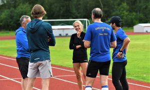 Efter en över tio år lång kamp mot ätstörningar är långdistanslöparen Nina Chydenius frisk. Hon trivs i träningsgemenskapen i Gamkarleby IF, där hon tränas av Håkan Prest (längst tv.). Nina Chydenius samtalar med träningskamrater på sportplan.