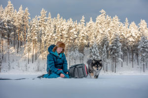 Emilia Laitinen ja suomenlapinkoira Mörö pilkillä Sallassa.