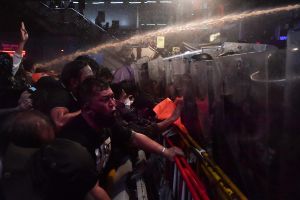 Polisen besköt demokratiaktivister med vattenkanoner i samband med fredagens protester. Thailändska aktivister besprutas med vatten.
