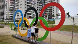 Lina, Oskar och Robert Kirmes i OS-byn i Rio 2016. Lina, Oskar och Robert Kirmes framför OS-ringarna i Rio 2016.