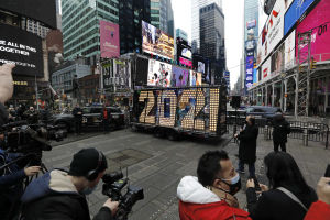 Times Square i New York håller i år stängt för besökare under nyårsaftonen. I dagarna installerades en nedräknare som ska filmas under kvällen och slutsekunderna av 2020. Fotografer omger en skylt av ledlampor som bildar siffrorna 2021.