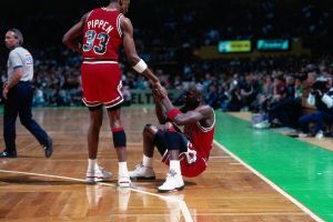 Chicago Bullsin Scottie Pippen ja Michael Jordan vuonna 1990. Koripalloilija Scottie Pippen auttaa Michael Jordania nousemaan maasta koripallo-ottelussa vuodelta 1990.