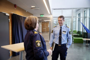 Det är ett samarbete mellan myndigheter, organisationer och civilsamhälle som har fått ner brottsstatistiken. Två poliser i uniform, en kvinna och en man, pratar med varandra i kontorsliknande lokal.