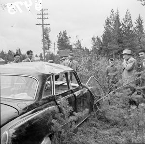 Lääninkomissaari tutkimassa varkaan kolaroimaa autoa 1957.
