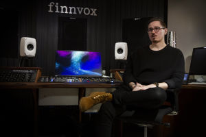 Mies istuu musiikkistudiossa, seinässä on Finnvoxin logo.