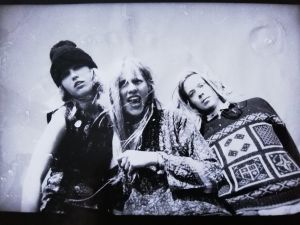 Islänskur Punkhoipur -bändi: kuvassa Niina Lehtonen, Tellervo ja Elias noin vuonna 1991. Niina, Tellervo ja Elias katsovat yläviistosta kameraa kohti valkoista taustaa vasten.