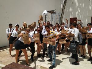 5.9 Cartuchos – Paper Bag Stories From Cuba -teokseen liittyvä kuva Havannan biennaalissa vuonna 2019. Kuubalaiset opiskelijat valmiina levittämään kaupungin torimyyjille teokseen liittyviä ruskeita paperipusseja. Iso ryhmä kuubalaisia opiskelijoita, käsissään ruskeita paperipusseja.