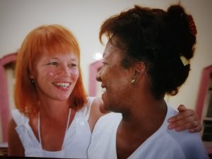 Kuvassa Jaana Kanninen on yhdessä kuubalaisen santeria-uskonnon harjoittajan kanssa. Kohtaaminen muodostui merkitykselliseksi, sillä nainen – etunimeltään Pastora – ällistytti Kannisen ja tämän puolison kertomalla heille heistä itsestään asioita, joita hän ei olisi mitenkään voinut ennalta tietää. Jaana Kanninen ja kuubalainen Pastora katsovat toisiaan nauraen.