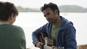 Yesterday, all my troubles seemed so far away... Jack (Himesh Patel) sjunger och spelar på gitarren vid en strand.