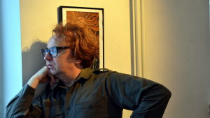 Pertti Jarla har också sitt arbetsrum i galleriet. Bildkonstnär står vid ett fönster.