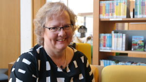 Lena Marander-Eklund är biträdande professor i folkloristik vid Åbo Akademi och säger att det inte lönar sig att bli hemskt upprörd över ändrade traditioner. Lena Marander-Eklund sitter framför en bokhylla.