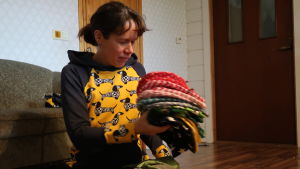 Anna Karamäki tycker att det är kul och kreativt att få jobba med barnkläder. Anna Karamäki radar upp mössor med glada mönster.