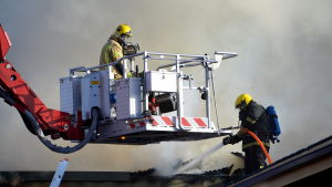 Det kan vara svårt att uppfatta vad en brandman säger bakom syrgasmasken. Brandmän släcker takbrand.