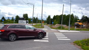 Bilen ska väja. Den svängande bilisten ska lämna företräde för de fotgängare och cyklister som är på väg över vägen som han svänger in på. Bil vid korsning på landsväg.