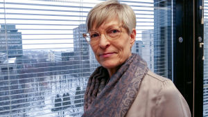 Diskrimineringsombudsmannen Kirsi Pimiä. Kirsi Pimiä står framför ett fönster. Hon är Diskrimineringsombudsman i Finland.