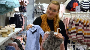 Det är inte så noga med hur man gör på individnivå utan borde se på den stora bilden, anser doktoranden Nina Nyman. Nina Nyman håller upp en blå skjorta med fluga och flickigare barnkläder i andra handen.