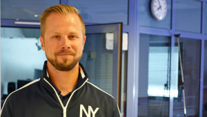 Matias Sirkkinen tror att konduktörerna i fortsättningen också kommer att synas i tågen. Sälja biljetter kommer de inte att göra. Matias Sarkkinen med vägg & fönster i bakgrunden.