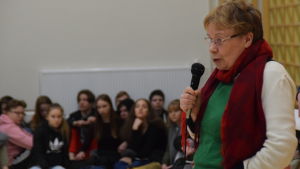 Tuula-Maria Ahonen uppmuntrar finska elever i Karis. kvinna talar i mikrofon till ungdomar i gymnastiksal