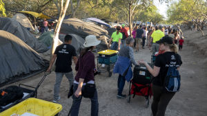 Frivilliga delar ut mat i migrantlägret i Matamoros i Mexico vid gränsen mot USA. Frivilliga delar ut mat i migrantlägret i Matamoros i Mexico vid gränsen mot USA.