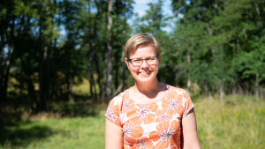 Miljöminister Krista Mikkonen är nöjd över att naturskyddet prioriteras. Kvinna i skogen.