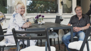 Maritta och Risto Pellava njuter av pensionärslivet i Sunila - de har satt sig i kö för ett nybygge närmare stan, men tanken på att flytta känns ändå sorglig. Maritta och Risto Pellava njuter av varsitt glas vin på sin veranda.