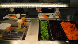 Mer variation i salladsbordet hade eleverna önskat. Brickor på en lunchkö i en skolmatsal vid salladsbordet där det finns gröna ärter, riven morot och inlagd rödbeta.