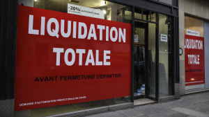 Butik i Paris som tvingas lägga ned på grund av pandemin. Skyltfönster täckta med blodröda anslag med texten "Liquidation totale".
