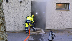 En hel del ånga kom tidvis ut ur källaren. Brandman som jobbar med att pumpa ut vatten.