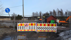 Tennisplanen, ishockeyrinken och omklädningshytten i Ingå måste flytta på sig eftersom området ska bli ett nytt bostadskvarter. Byggarbetsplats med rinkens omklädningsrum i bakgrunden.