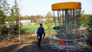 Rolf Englund föredrar egentligen parkbanor, men skogsbanor med höjdskillnader har också sin charm säger han. En man kastar frisbeegolf mot en korg som finns uppe på ett berg.