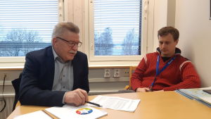 Fullmäktigeordförande Unto Pasanen (C) och kommundirektör Matias Hilden analyserar en gammal konsultrapport, som gjordes då läget såg dystert ut. Enligt rapporten skulle Puumala inte klara sig utan fusion och den kommunala skattesatsen förutspåddes år 2017 vara 25 procent. Fullmäktigeordförande Unto Pasanen och kommundirektör Matias Hilden i Puumala förevisar ekonomiska siffror på kommunkansliet.