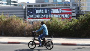 Det gick inte som Israels hoppades i det amerikanska presidentvalet. USA:s nya Israelpolitik kan se annorlunda ut än under Trumps tid. En man i Tel Aviv cyklar förbi en skylt som säger att Israel behöver Donald Trump flera år till.