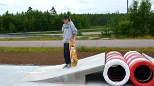 Caben, alltså hindret man ska hoppa över ser ut så här. Pojke står på liten betongramp och håller i skateboard