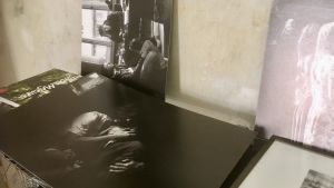 På ett bord i Gints Grūbes arbetsrum finns bilder som återspeglar Lettlands plågsamma närhistoria. Svartvita bilder med scener ur Lettlands sovjetiska historia på filmregissören Gints Grūbes bord.