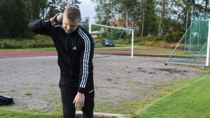 Mikael hoppas nå final i kulstötningen. Mikael Kock håller en kulstötnings kula mot nacken, redo att stöta.