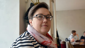 Irina Kujanpää tänker ta kommunens nätverk i bruk. Närbild på en kvinna i randig tröja.