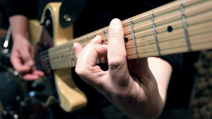 Gitarren är en väsentlig del av genren surfrock. Valokuva haastateltavasta soittamassa kitaraa