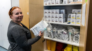Sjukskötare Paula Mårtens och skåpet med nålarna. Paula Mårtens ser över förrådet av sprutor.