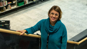 Malin Hollmén - chef för bibliotekstjänster i Borgå. Malin Hollmén står i en trappa.