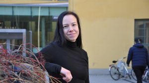 Petra Lindblad är studentombud vid Åbo Akademis studentkår. Lutar sig mot ett staket ute på gården.