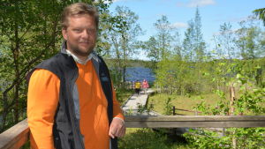Henrik Jansson ser med förväntan fram emot hur busslinjen påverkar besöksantalet i sommar. Henrik Jansson framför sjön i Kurjenrahka Nationalpark