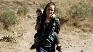 Tusentals jezidier tvingades fly sina hem undan IS angrepp kring Sinjar. Tusentals kvinnor och barn togs tillfånga och tvingades till slaveri medan de tillfångatagna männen dödades. Yazidisk kvinna flyr undan IS med sin son på ryggen.