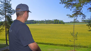 Christian Jensen ser ut över sina fält. En man som ser ut på sina fält från balkongen.