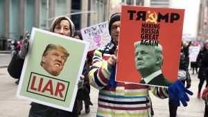 Många åsikter om Trumps sanningar. Bilden från en demonstration i New York. Två demonstrationsplakat mot Trump: "Lögnare" och "Gör Ryssland stort igen"