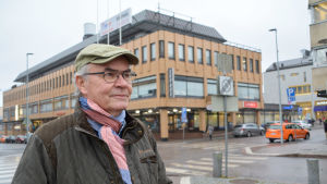 Mikko Broberg är delägare i företaget som äger Nimbushuset. Man i keps framför affärshus i centrala Borgå en grå novemberdag