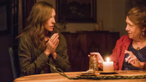 Jonej, Joan (Ann Dowd) är inte den man skall fråga råd av om hur du får kontakt med de döda. Annie (Toni Colette) och Joan (Ann Dowd) sitter vid ett bord med ett tänt ljus och håller seans.