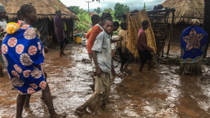 Invånare i en by går längs en översvämmad väg i Moçambique.