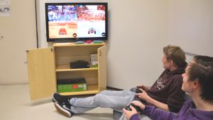 I pausrummet spelas i dag ett videospel där bilar spelar fotboll. Killarna spelar och vi ser färgranna bilar på TV-skärmen.